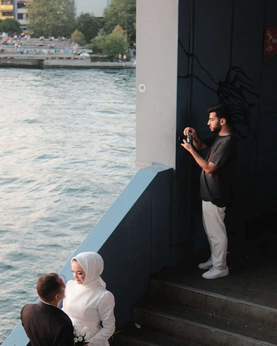 Photographer framing newlyweds by the water