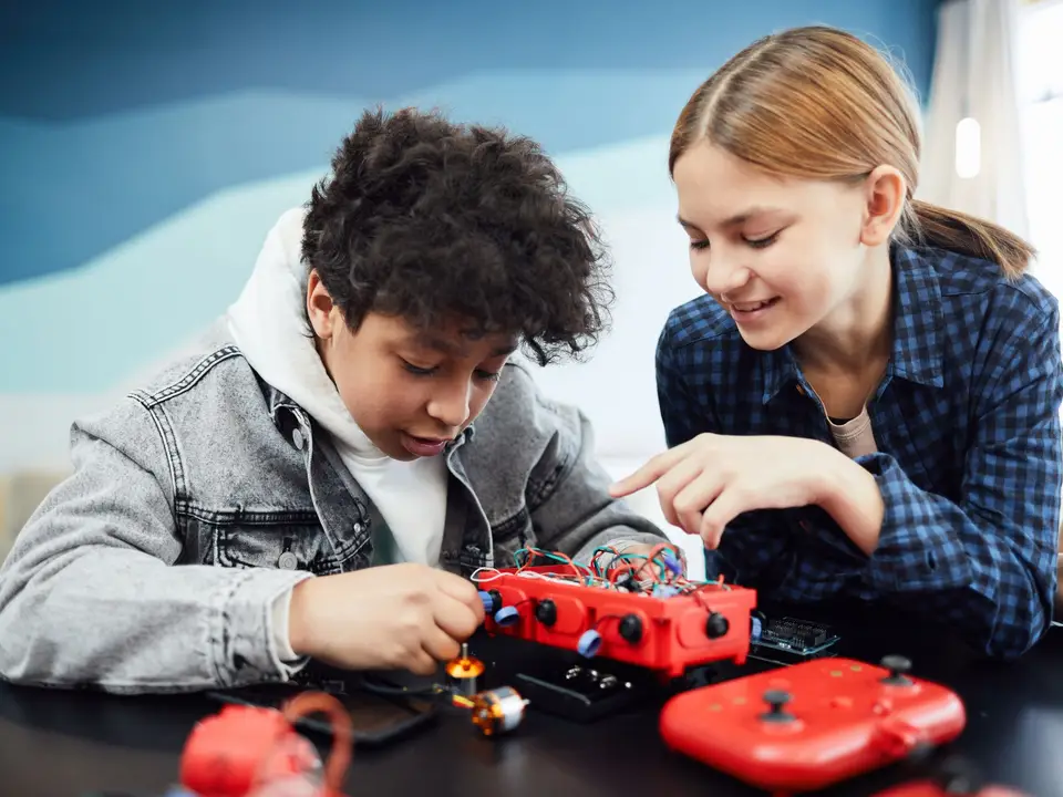 Kids collaborating on a robotics project, focusing on technology and learning indoors