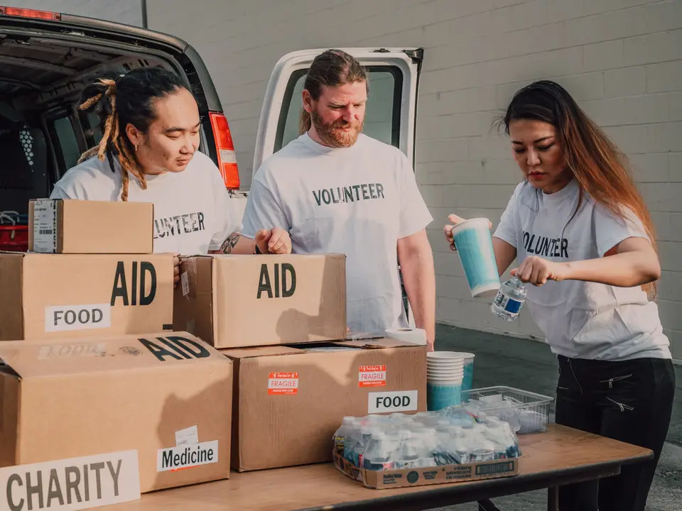 Young volunteers packing aid boxes at a distribution table
